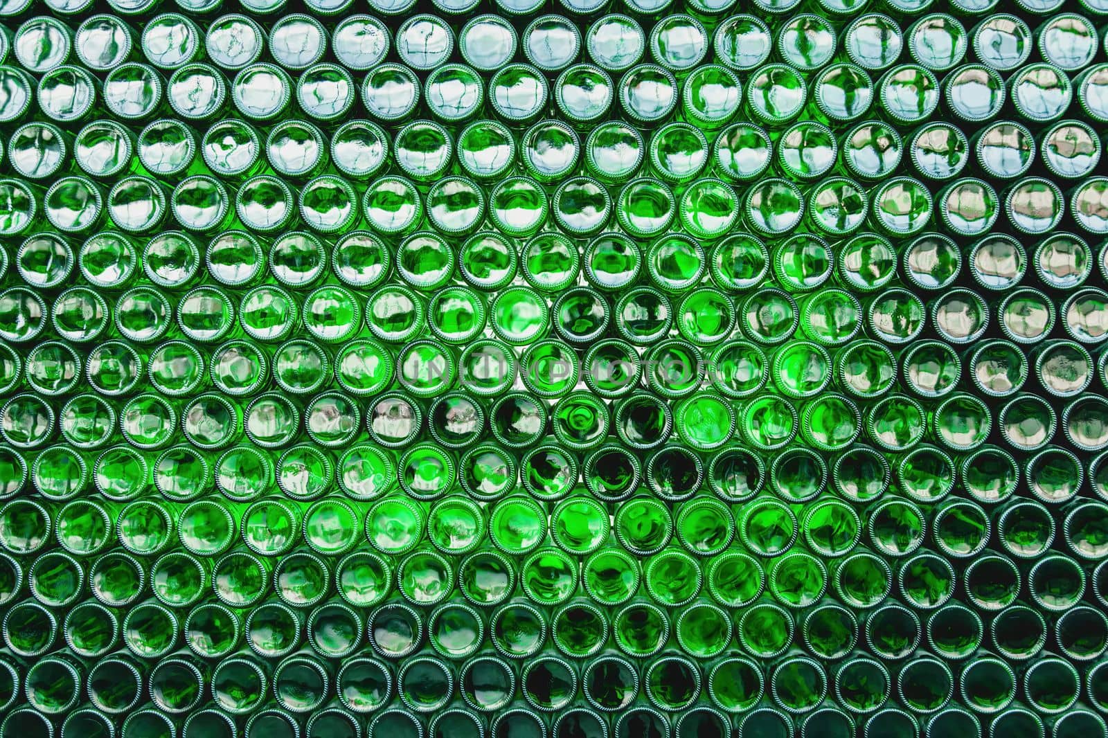 Glass bottles green. Green glass bottles of beer. Wall formed by green bottles. Green bottles background. Empty Glass Bottle with Lighting.