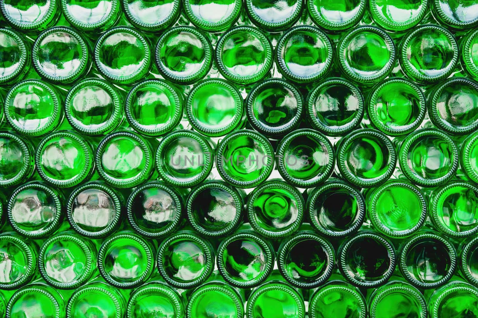 Glass bottles green. Green glass bottles of beer. Wall formed by green bottles. Green bottles background. Empty Glass Bottle with Lighting.