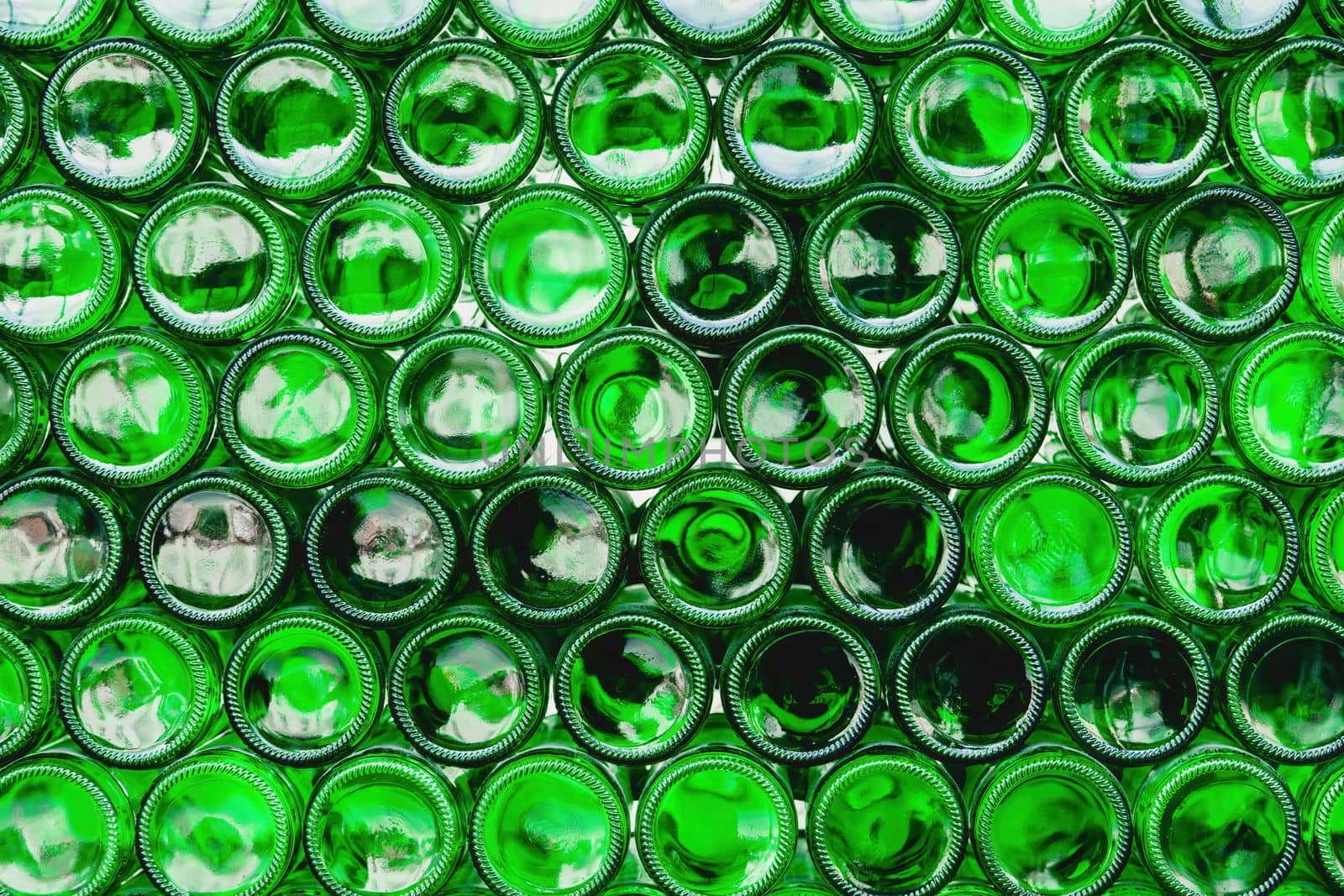 Glass bottles green. Green glass bottles of beer. Wall formed by green bottles. Green bottles background. Empty Glass Bottle with Lighting.