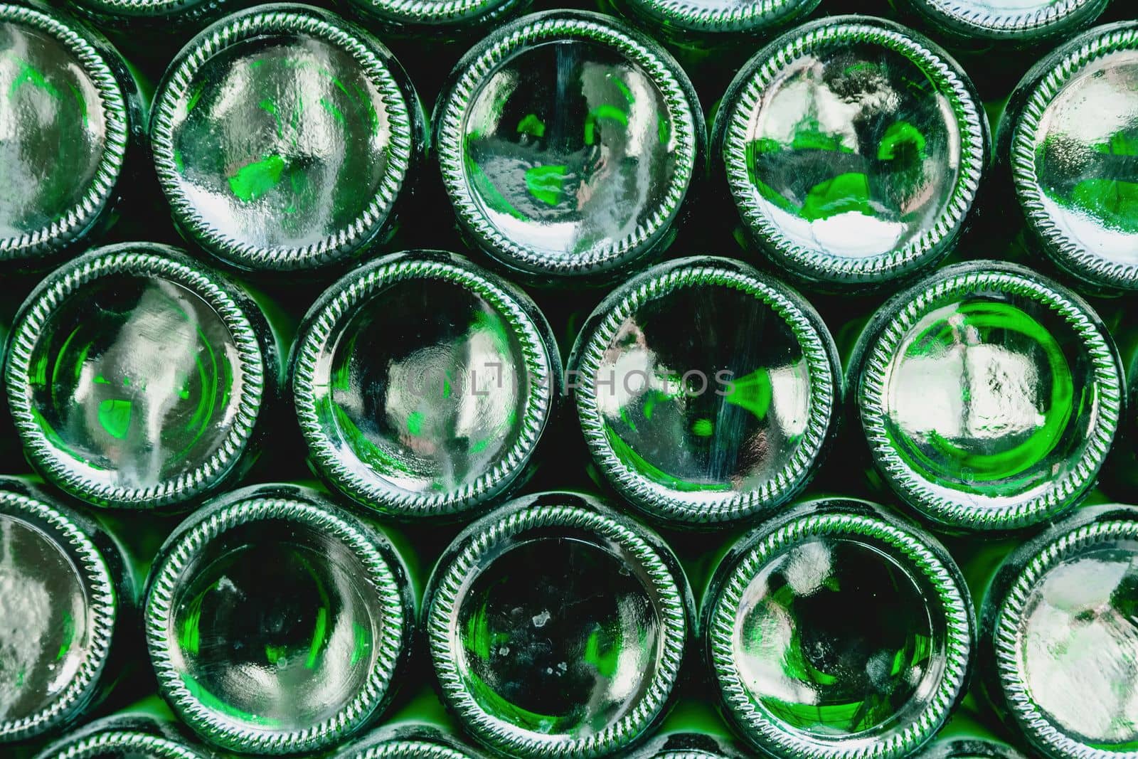 Glass bottles green. Green glass bottles of beer. Wall formed by green bottles. Green bottles background. Empty Glass Bottle with Lighting.