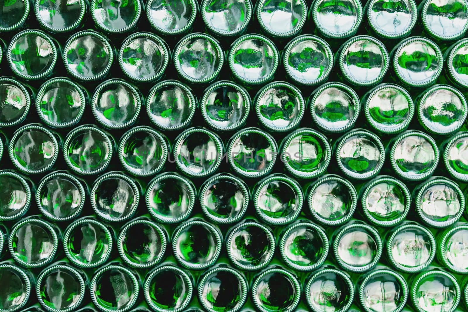 Glass bottles green. Green glass bottles of beer. Wall formed by green bottles. Green bottles background. Empty Glass Bottle with Lighting.