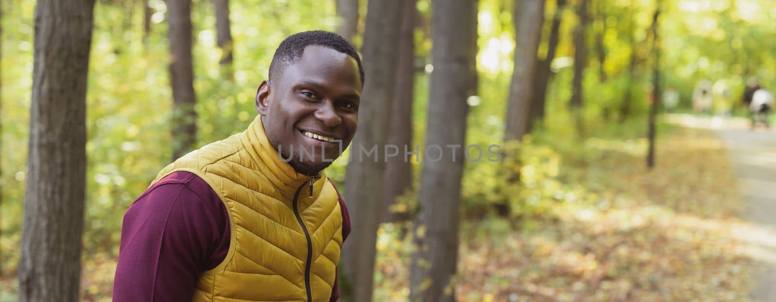 Banner African american man breathing fresh standing in spring park outdoors copy space and empty space for advertising. Well being and relaxation concept. by Satura86