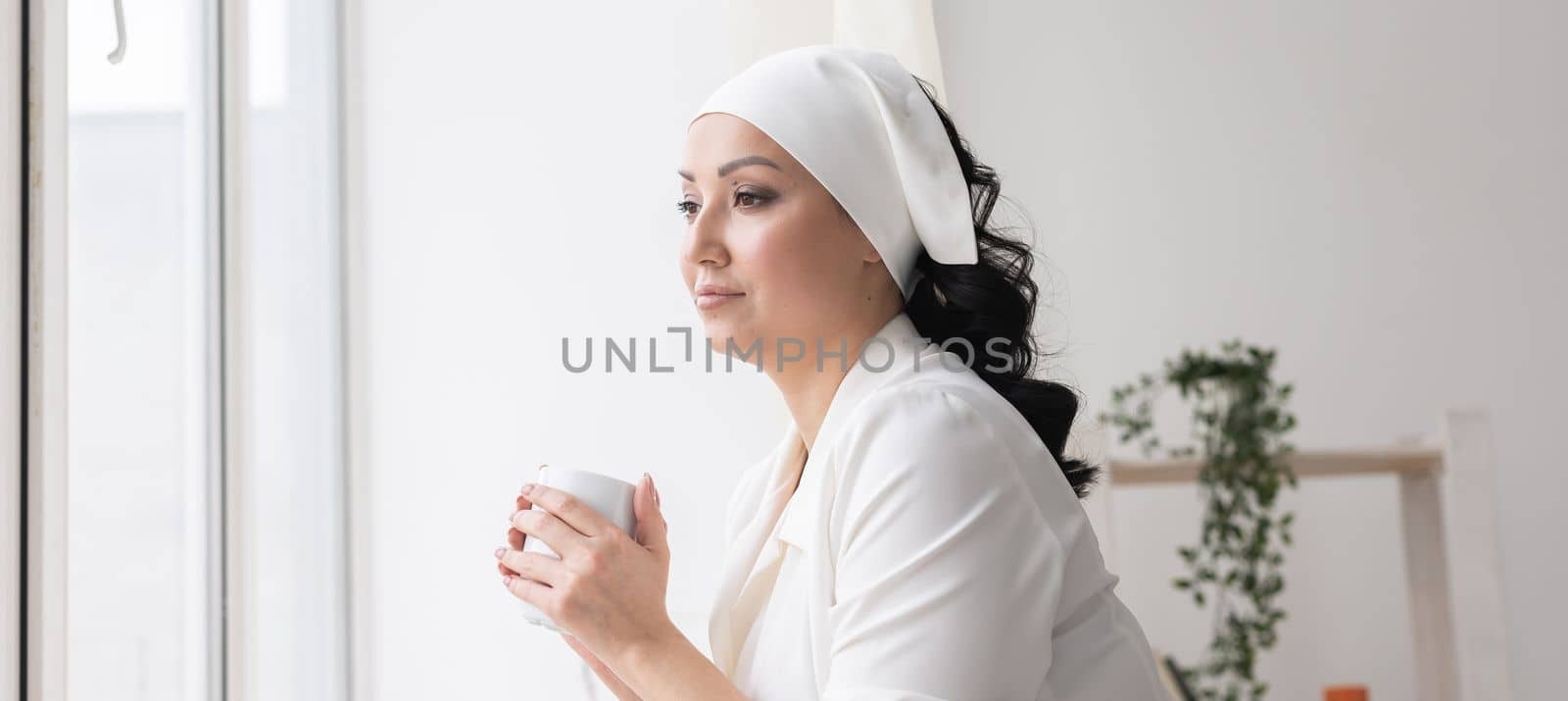 Banner beautician or nurse drinking coffee during a break on background beauty office. Portrait of professional beautician - copy space and empty place for advertising by Satura86