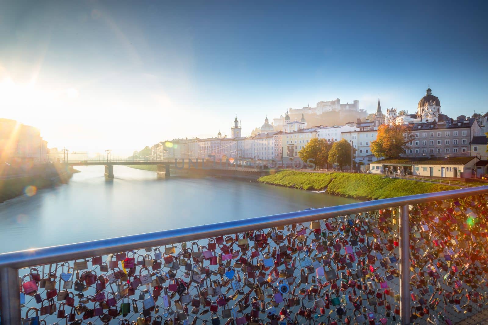 Beautiful view of Salzburg cityscape from Salzach River at misty sunrise, Austria