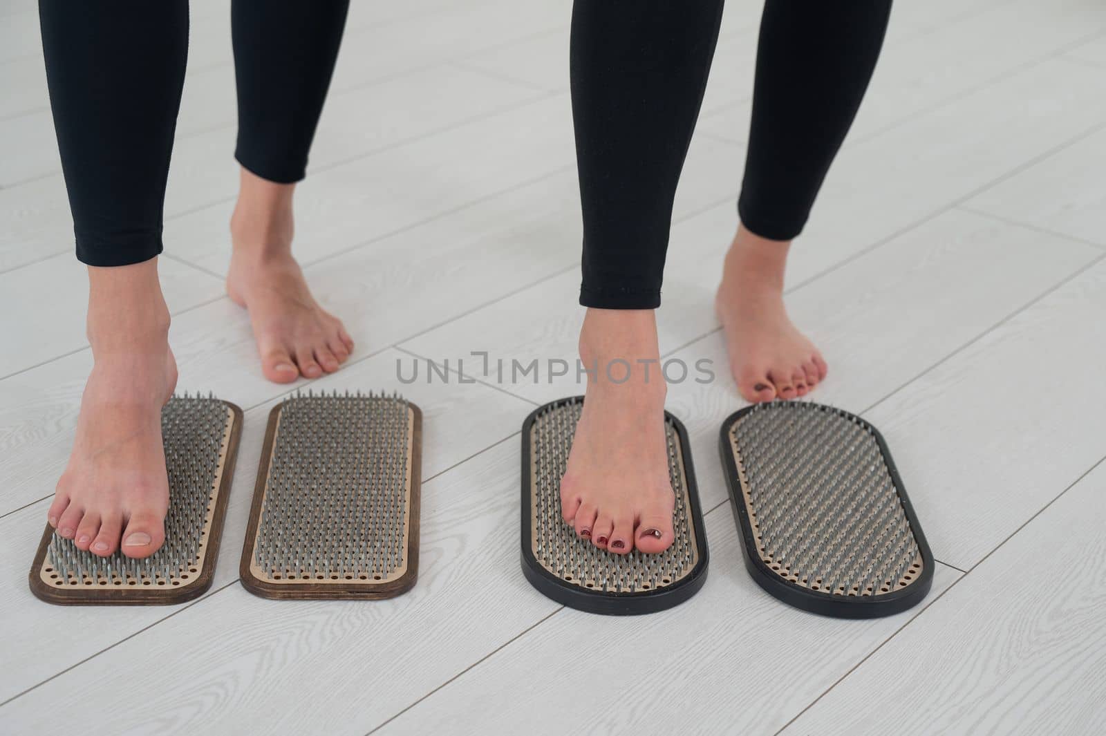 Close-up of two women's feet on sadhu's nails. Top view