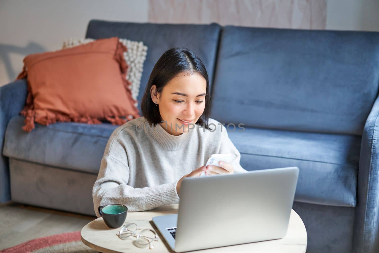 Work from home, freelance and e-learning concept. Young woman studying, sitting in front of laptop, working on remote, worplace in living room.