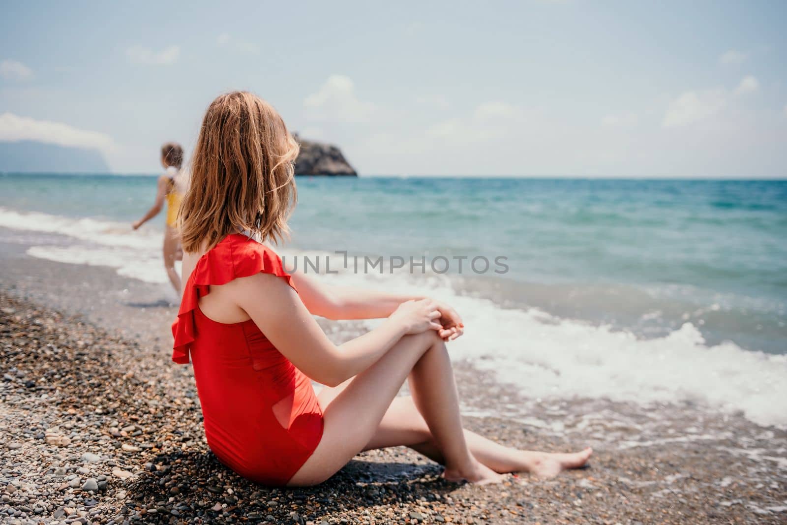 Happy loving family mother and daughter having fun together on the beach. Mum playing with her kid in holiday vacation next to the ocean - Family lifestyle and love concept by panophotograph