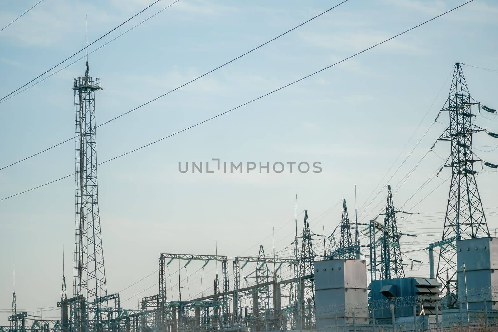 Silhouette High voltage electric tower on sunset time, distribution electric substation with power lines and transformers.