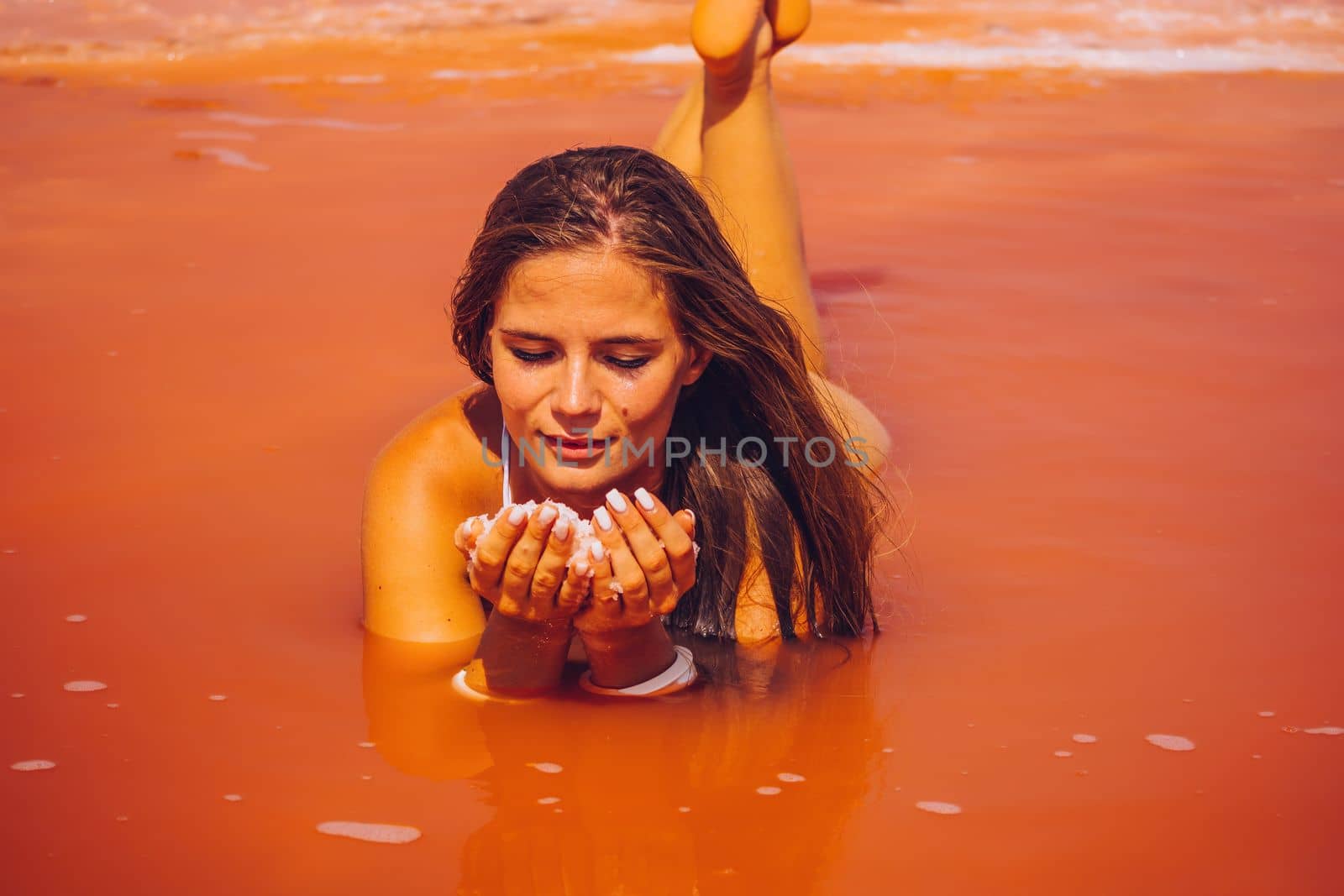 Salt mining. Salty pink lake with crystals of salt. Extremely salty pink lake, colored by microalgae with crystalline salt depositions