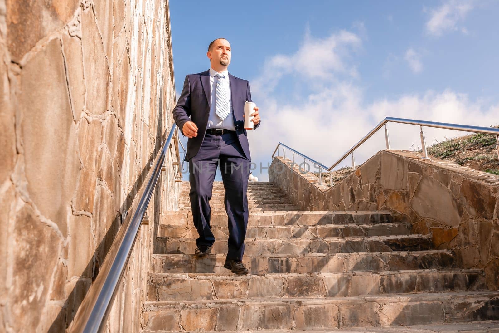 Business executive with briefcase going down the stairs.