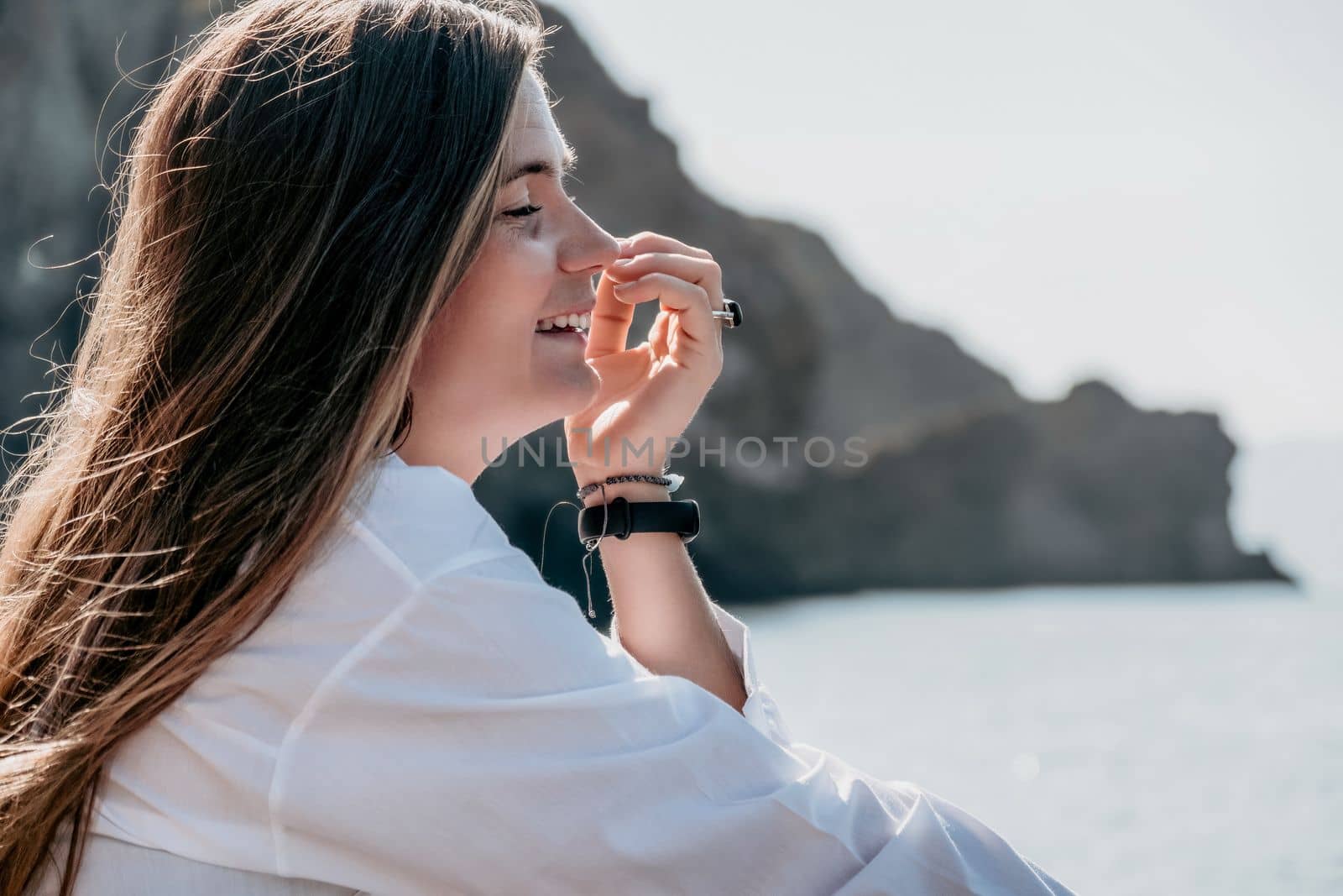 Young woman in black bikini and white shirt on Beach. Girl lying on pebble beach and enjoying sun. Happy lady in bathing suit chilling and sunbathing by turquoise sea ocean on hot summer day. Close up by panophotograph
