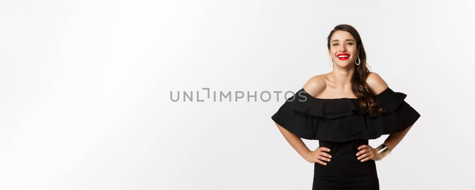 Beauty and fashion concept. Elegant young woman wearing party dress and red lipstick, laughing at camera, standing cheerful against white background by Benzoix