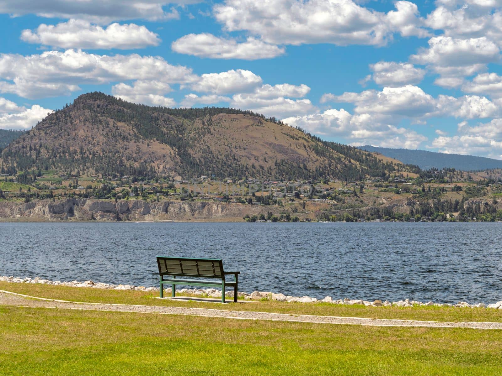 Scenery Okanagan lake overview with the bench at the pathway along the waterfront