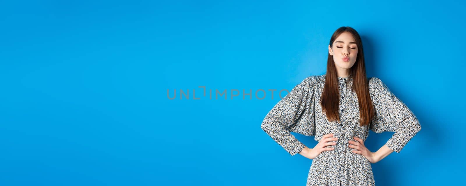 Valentines day and relationship concept. Romantic woman with closed eyes kissing lover, pucker lips and kissing you, standing on blue background by Benzoix