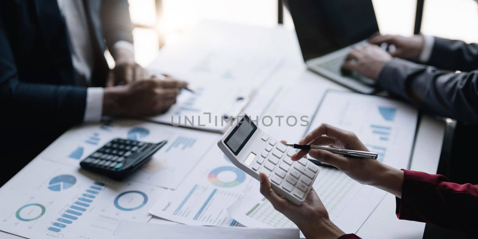 Group of confident business people point to graphs and charts to analyze market data, balance sheet, account, net profit to plan new sales strategies to increase production capacity