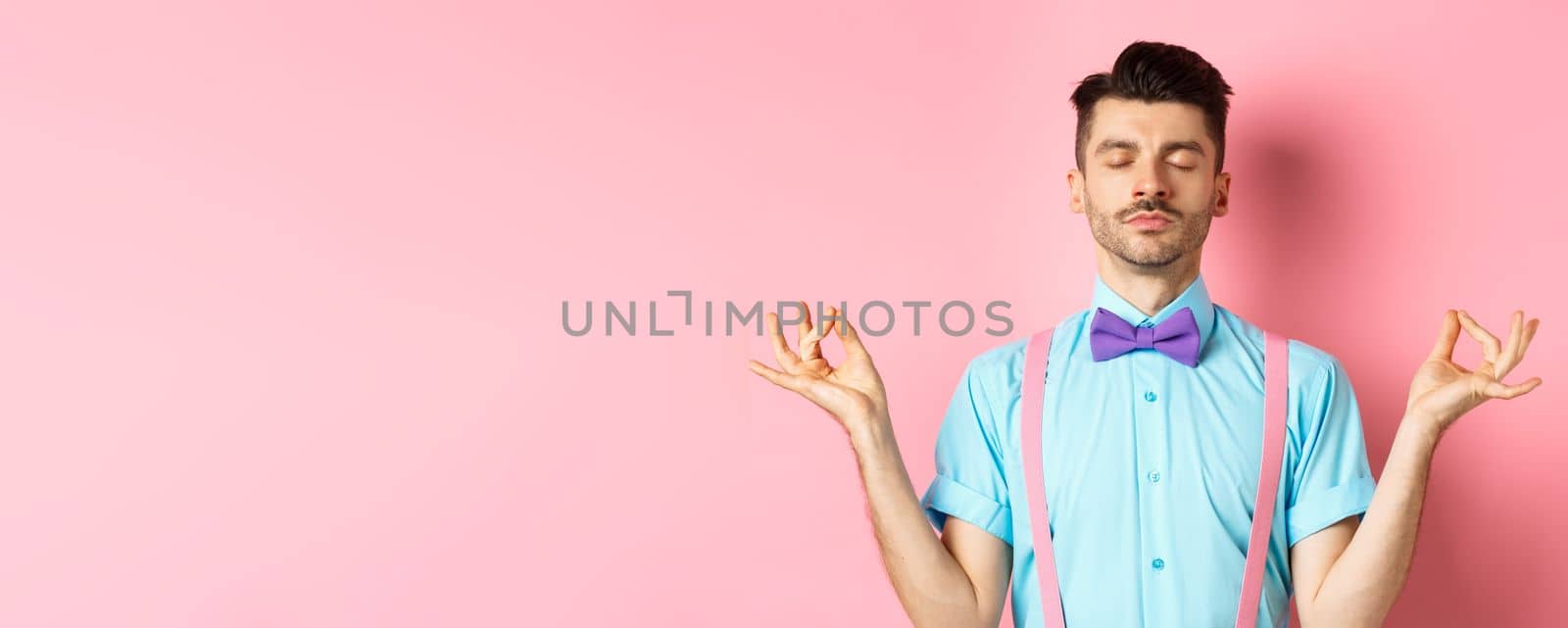 Young guy in bow-tie standing calm and peaceful, meditating with hands in mudra zen gesture and closed eyes, practice yoga to relax, standing over pink background by Benzoix