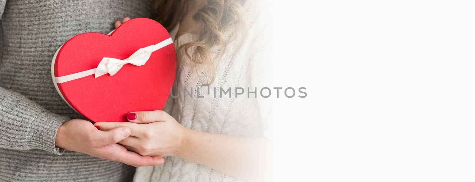 Banner Valentine's day, holiday and gift concept. Close-up of happy young couple with valentine's day present isolated on white background copy space. Happy Man giving a gift to his girlfriend. by Satura86