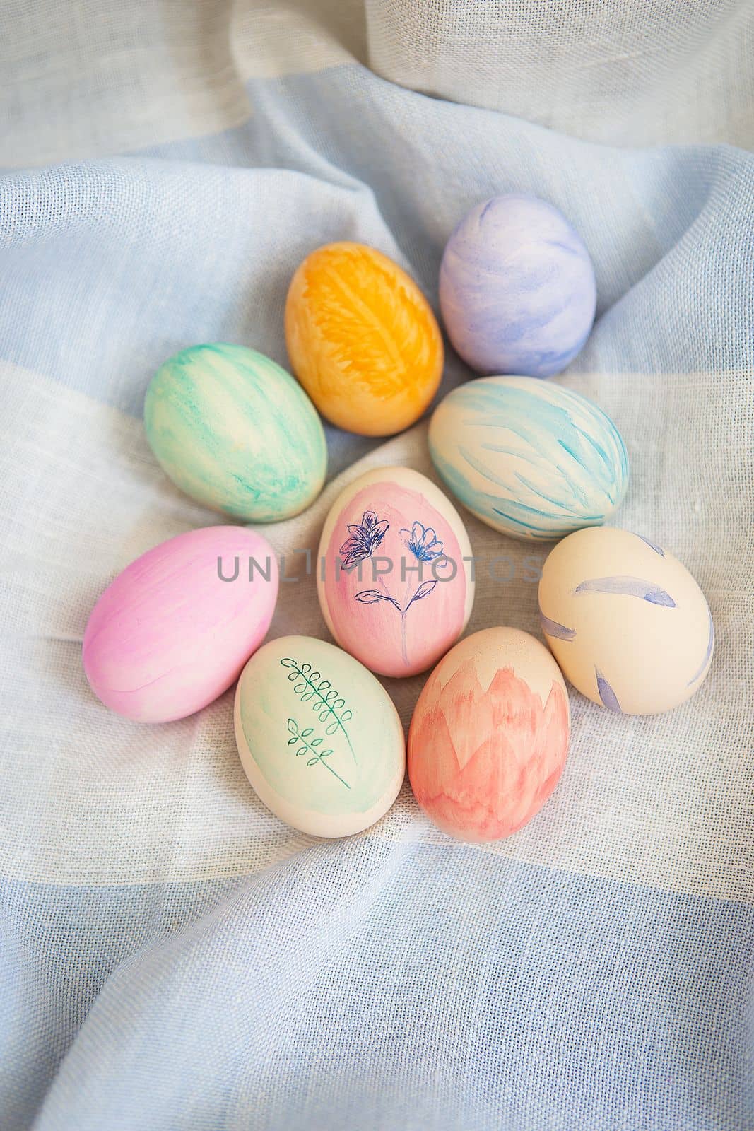 Painted bright and multi-colored Easter eggs on the background of a linen tablecloth, eggs painted with watercolors