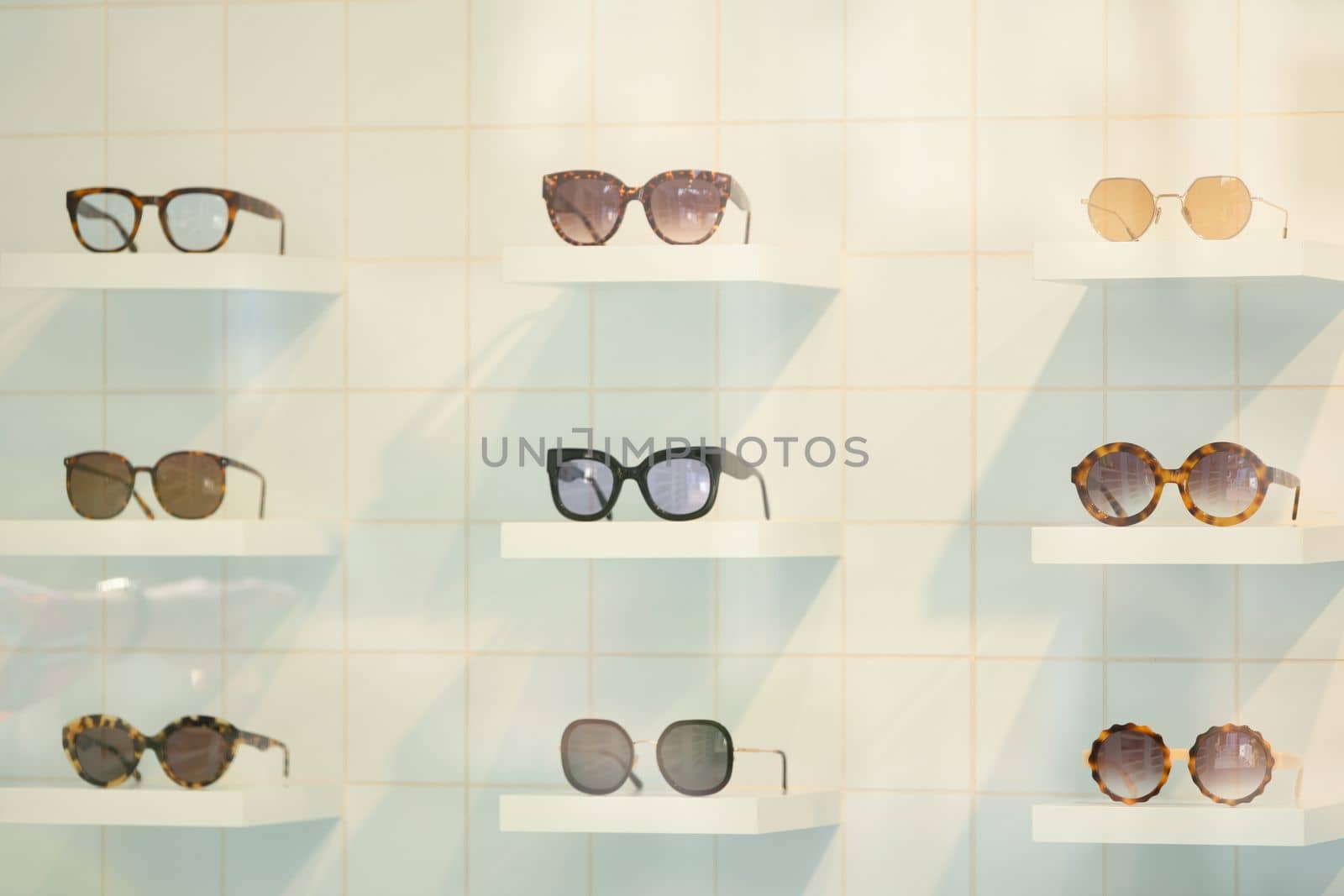 Exhibitor of glasses consisting of shelves of fashionable glasses shown on a wall at the optical shop