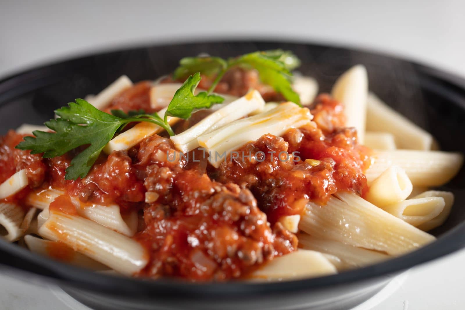 Pasta Penne with Tomato Bolognese Sauce, Parmesan Cheese and Basil. . High quality photo