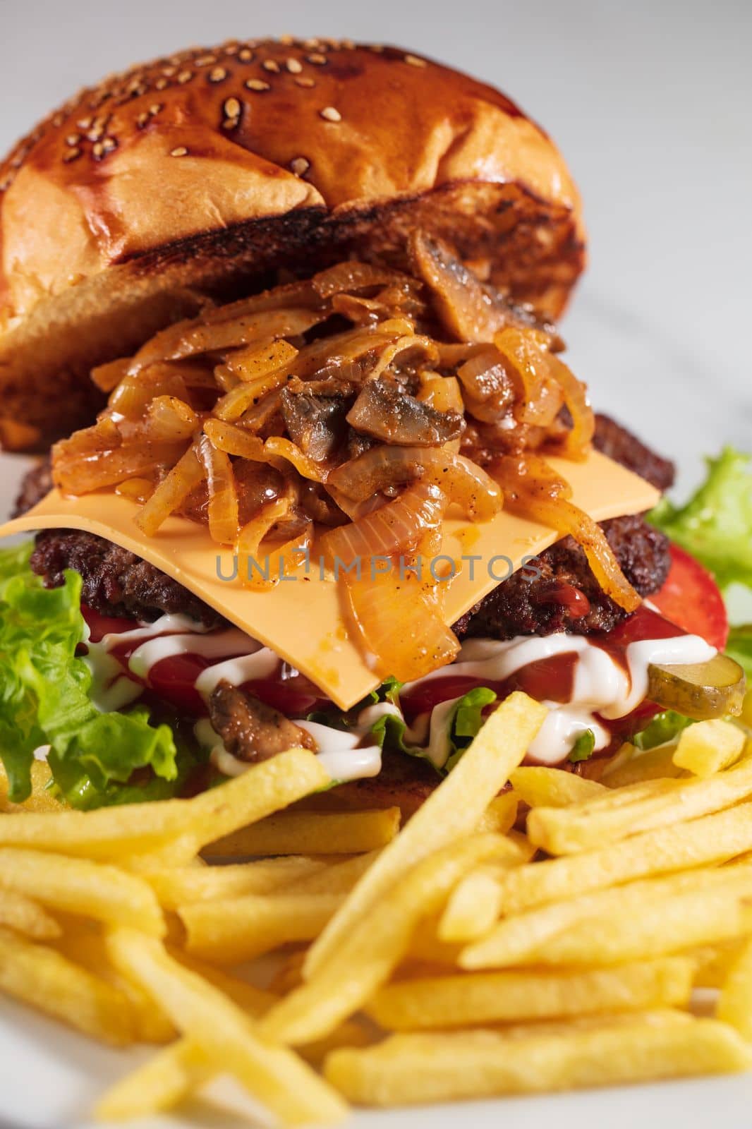 cheeseburger and fries on plate served at restaurant by senkaya