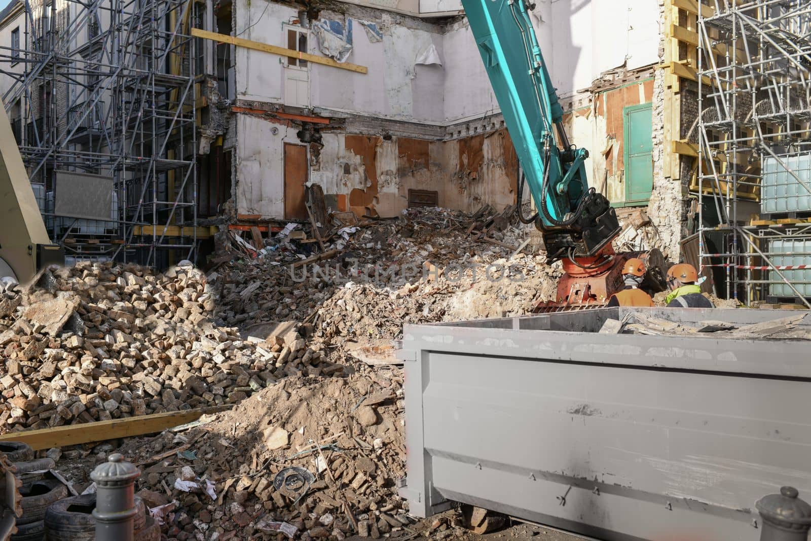 Ruined house. An excavator destroys a house with a bucket.