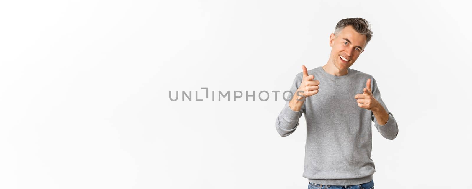 Portrait of handsome and confident middle-aged man, showing thumbs-up and smiling satisfied, approve and like something good, standing over white background.