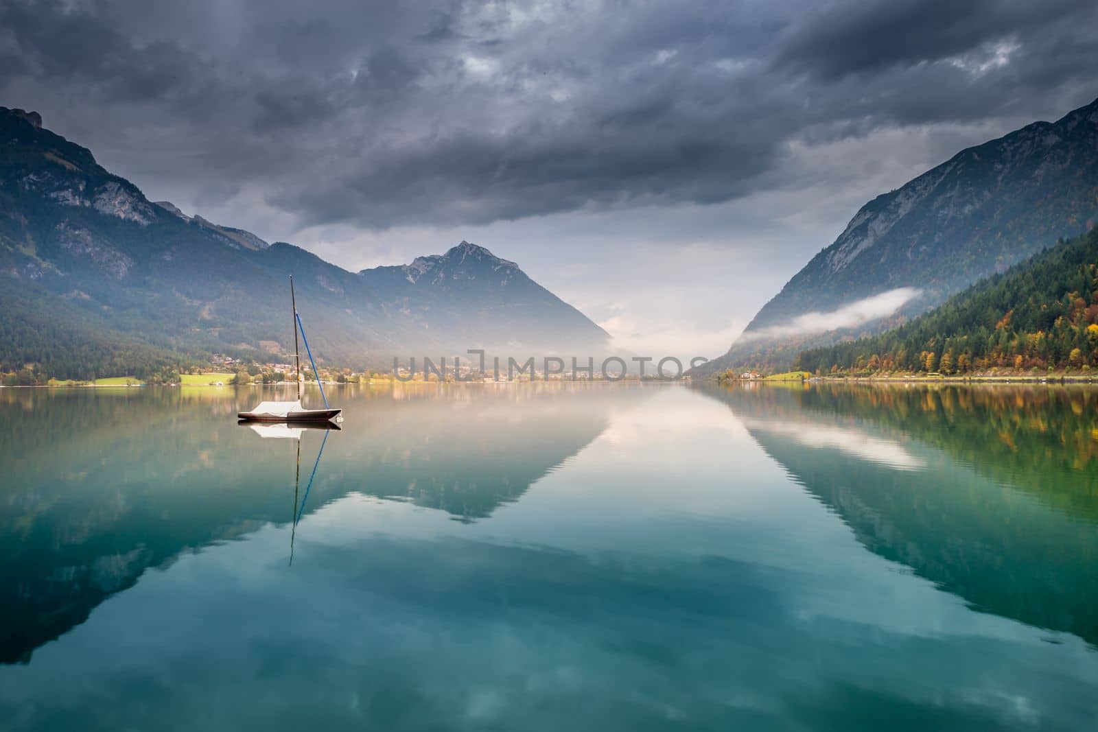 Sailboats on Achensee lake near Innsbruck at peaceful misty dawn, Tyrol alps, Austria