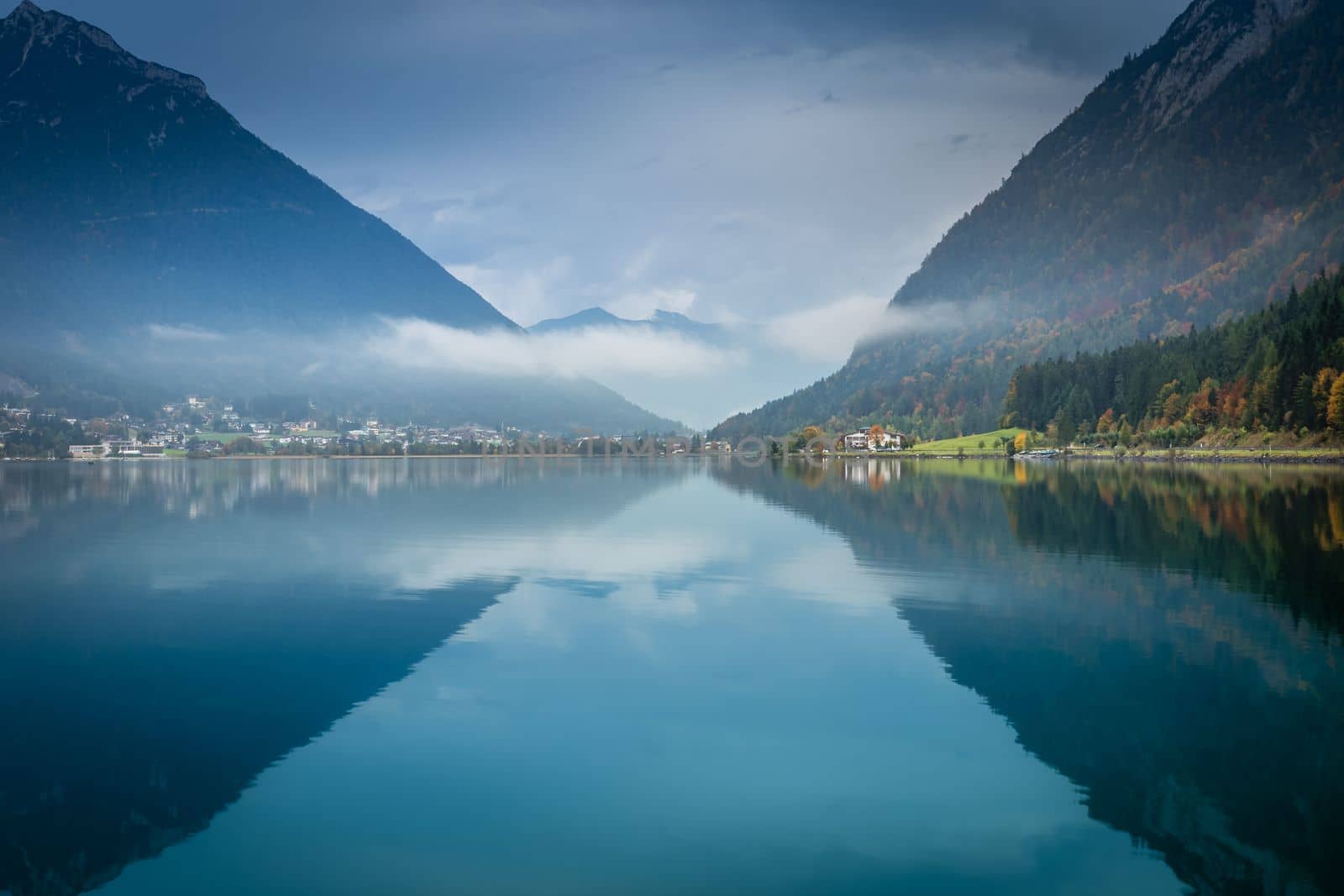 Sailboats on Achensee lake near Innsbruck at peaceful misty dawn, Tyrol alps, Austria