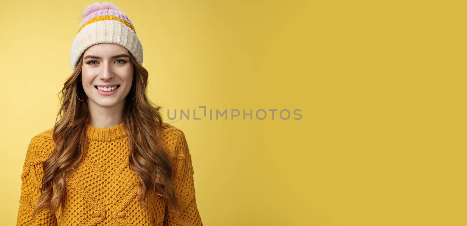 Attractive young friendly-looking outgoing girl dressed warm travel mountains skiing having fun spend winter holidays alps family, smiling broadly wearing corduroy hat sweater, yellow background.