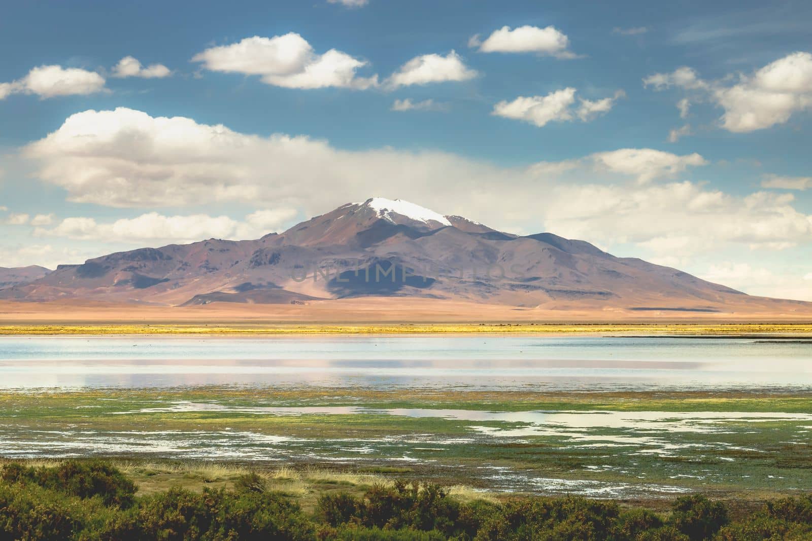 Salt lake reflection and idyllic volcanic landscape at Sunset, Atacama desert, Chile border with Bolivia