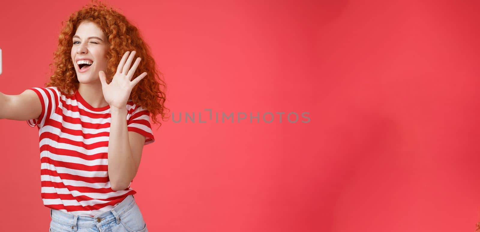 Cheerful friendly energized good-looking redhead curly-haired female send hello waving palm smiling broadly blogger record life stream talking fans grinning taking selfie summer holiday trip by Benzoix