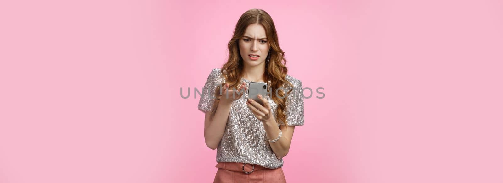 Frustrated pissed woman keep receiving strange messages cringing grimacing bothered look smartphone display gesturing irritated confused, cannot understand article, pink background by Benzoix