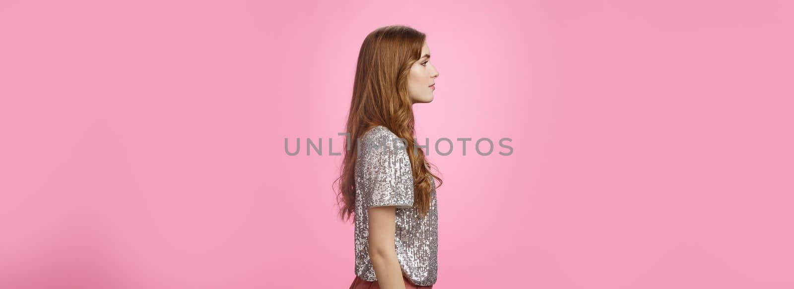 Profile studio shot fashionable glamour girl standing turning left casual pose wait queue enter famour night club have fun dance night, wearing glittering stylish blouse skirts, pink background.