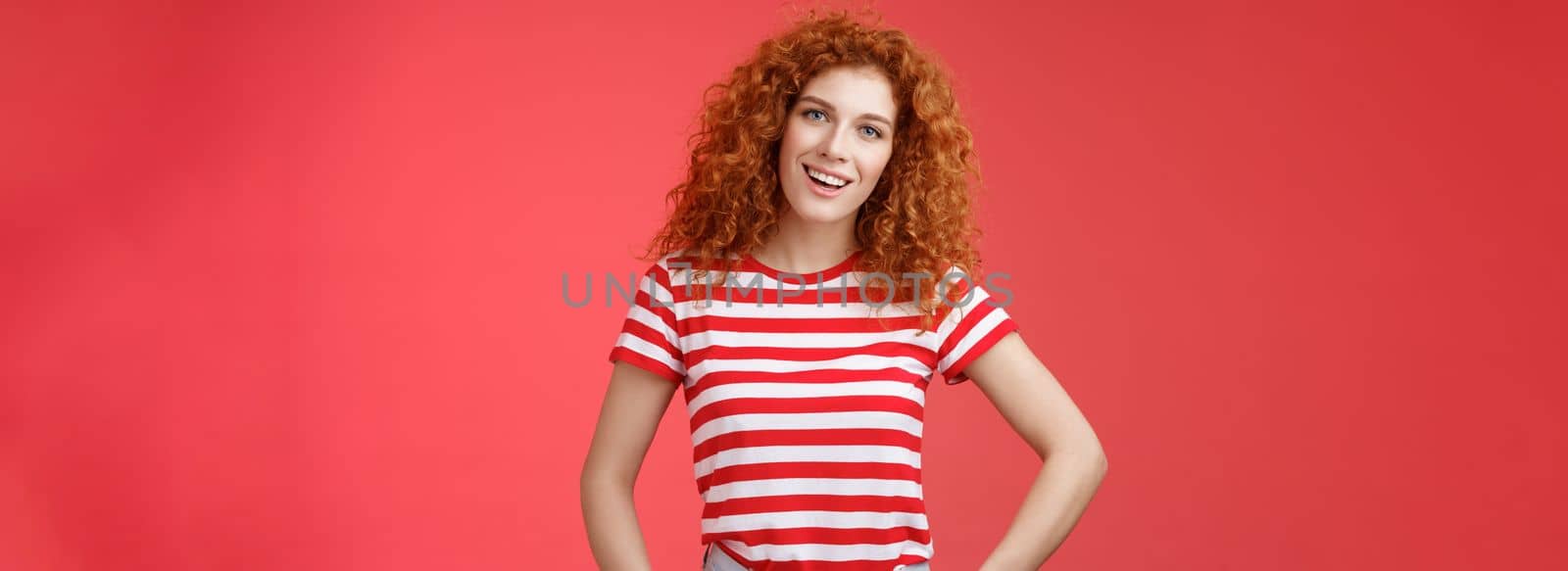 How hanging. Friendly carefree redhead curly-haired relaxed outgoing woman speaking casually entertained happy mood hold hands jeans pockets tilt head intrigued, curiously look camera.