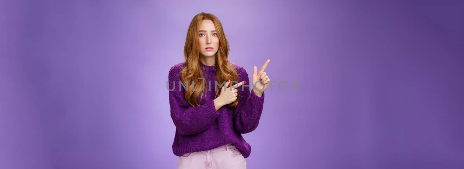 Lifestyle. Upset and gloomy woman in sorrow feeling regret of missing huge sales looking reckelss and unhappy pointing questioned at upper left corner with hopeless expression over purple background.