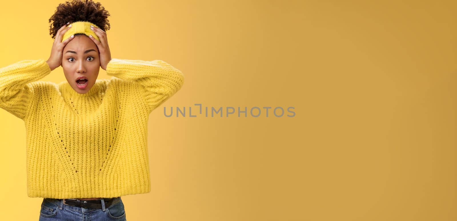 Concerned troubled surprised african-american woman gasping shocked hold head widen eyes perplexed face troublesome situation panic unaware what do, standing frustrated yellow background.