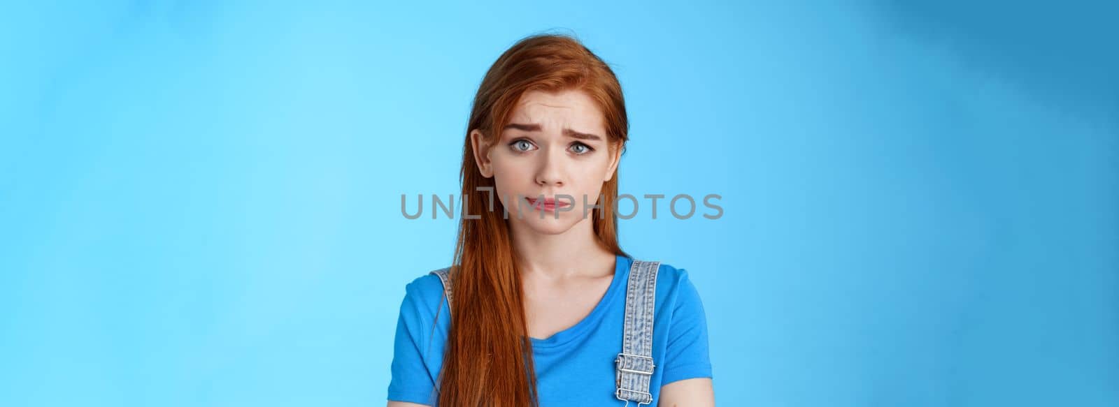 Doubtful questioned girlfriend look camera full disbelief, raise eyebrow frowning confused, hear strange weird nonsense talks, stand blue background, smirk unsatisfied, feel uncomfortable.