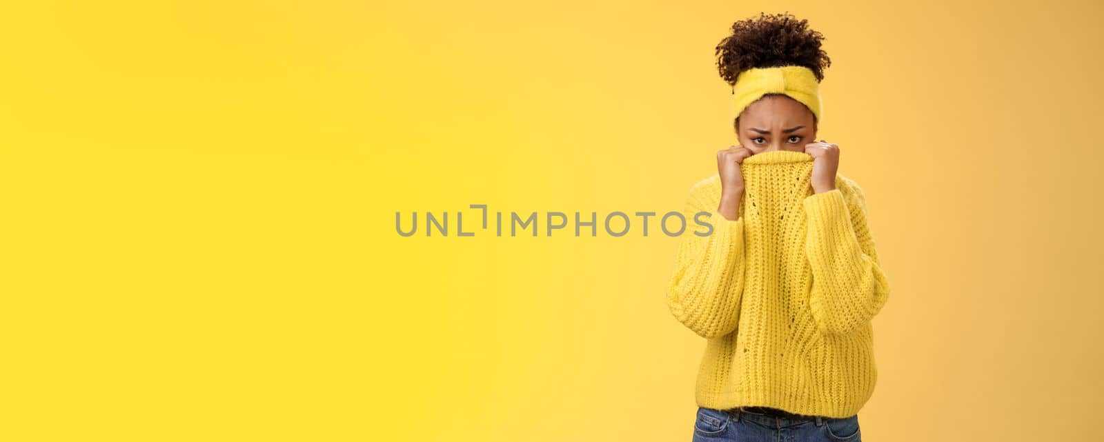 Cute upset scared timid insecure african-american offended girl hiding face pulling sweater collar nose frowning pouting look sorrow insulted afraid watching scary horror movie alone, need support.