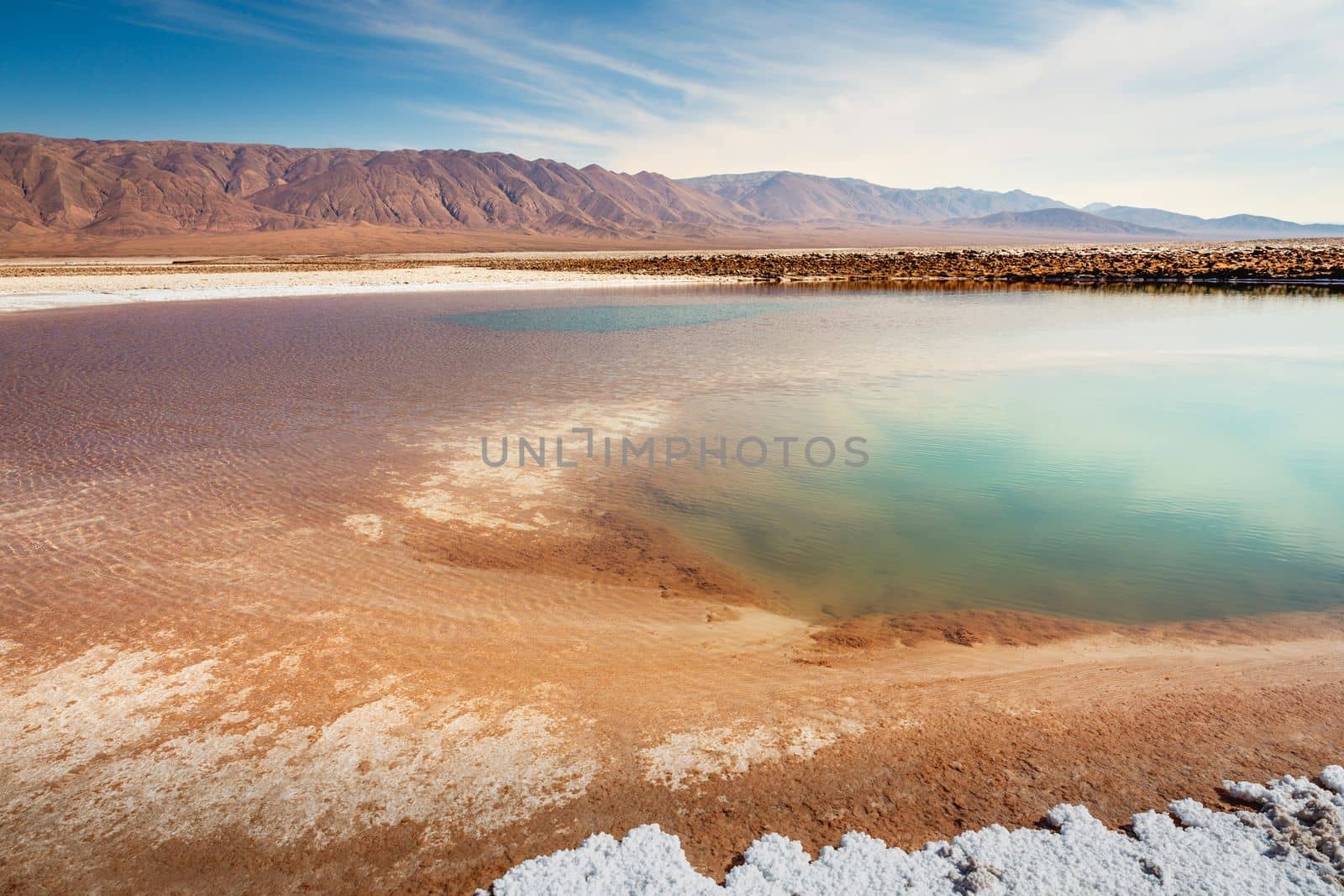 Salt lake reflection and idyllic volcanic landscape at sunrise, Atacama desert, Chile border with Bolivia
