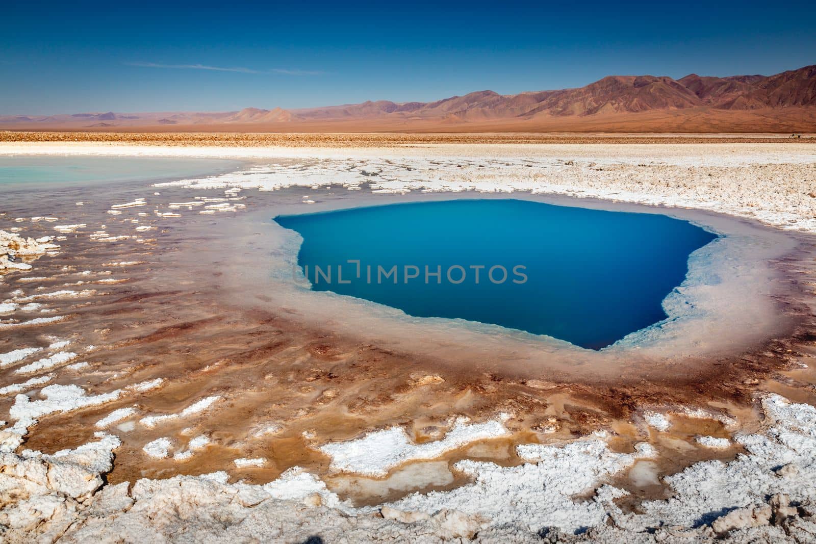 Salt lake reflection and idyllic volcanic landscape at sunrise, Atacama desert, Chile border with Bolivia