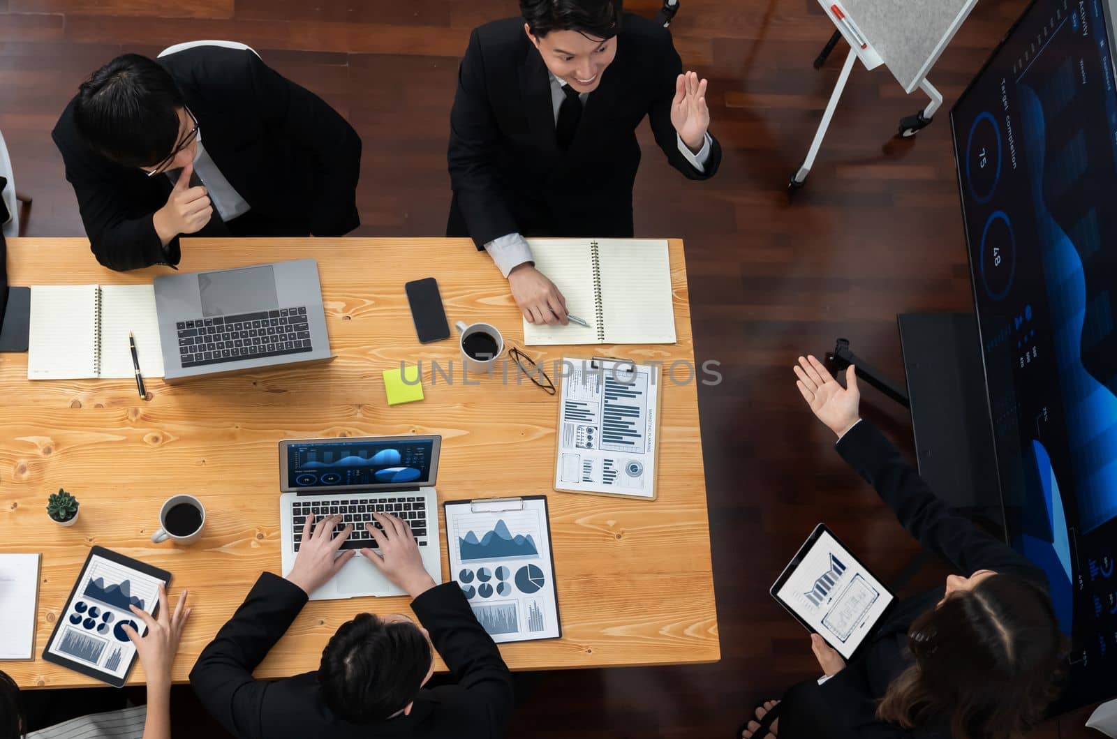 Top-view business team of financial data analysis meeting with business intelligence, report paper and dashboard on laptop for marketing strategy. Business people working together in office of harmony
