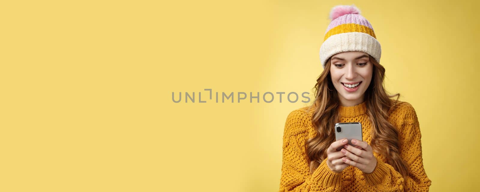 Amazed surprised cute girl receive good news reading exciting message hold smartphone widen eyes smiling mobile phone display, playing awesome cellphone game texting, send pics winters vacation by Benzoix