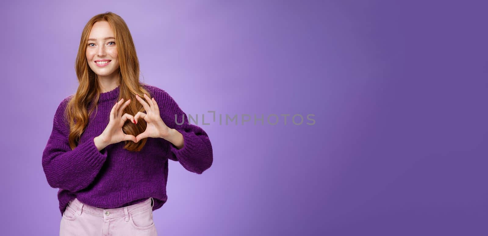 Girl loves new place to hang out, showing heart gesture and smiling satisfied and cute, expressing sympathy and admiration looking romantic and dreamy against purple background by Benzoix