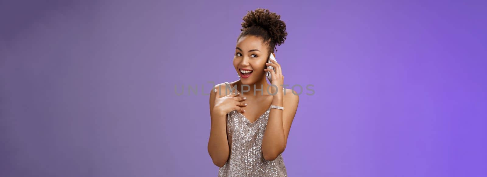Attractive wealthy talkative pleased african american girl discuss silly things calling friend smartphone speaking phone gesturing pointing herself bragging during phonecall standing blue background by Benzoix