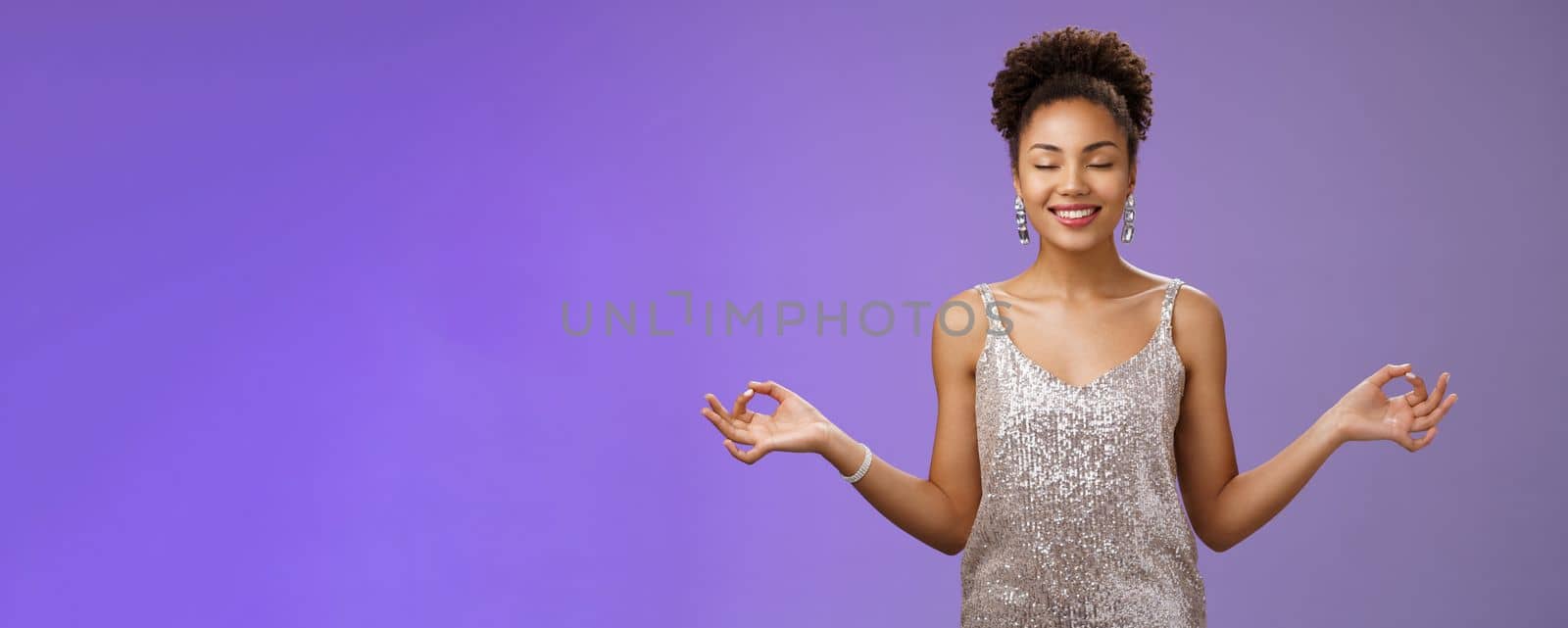 Happy relieved elegant african american woman luxurious evening silver glittering dress smiling happily feel rejoice stress-free calm down meditating breathing excercise find nirvana yoga pose by Benzoix