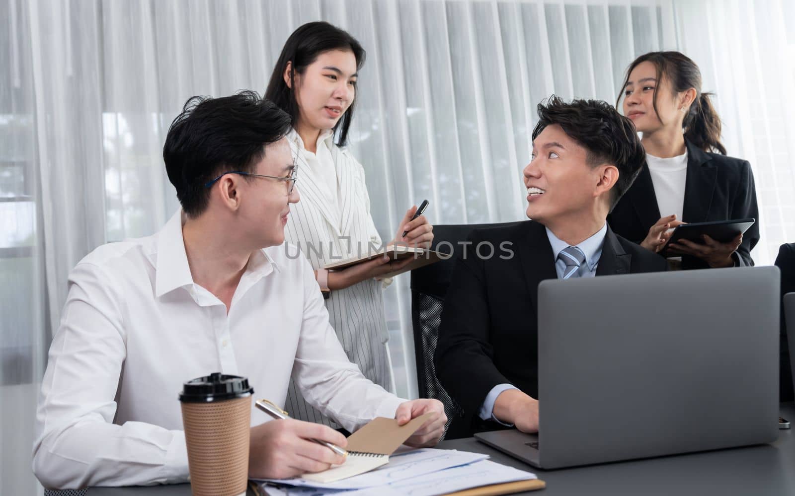 Harmony in office concept as business people analyzing dashboard paper together in workplace. Young colleagues give ideas at manager desk for discussion or strategy planning about project.