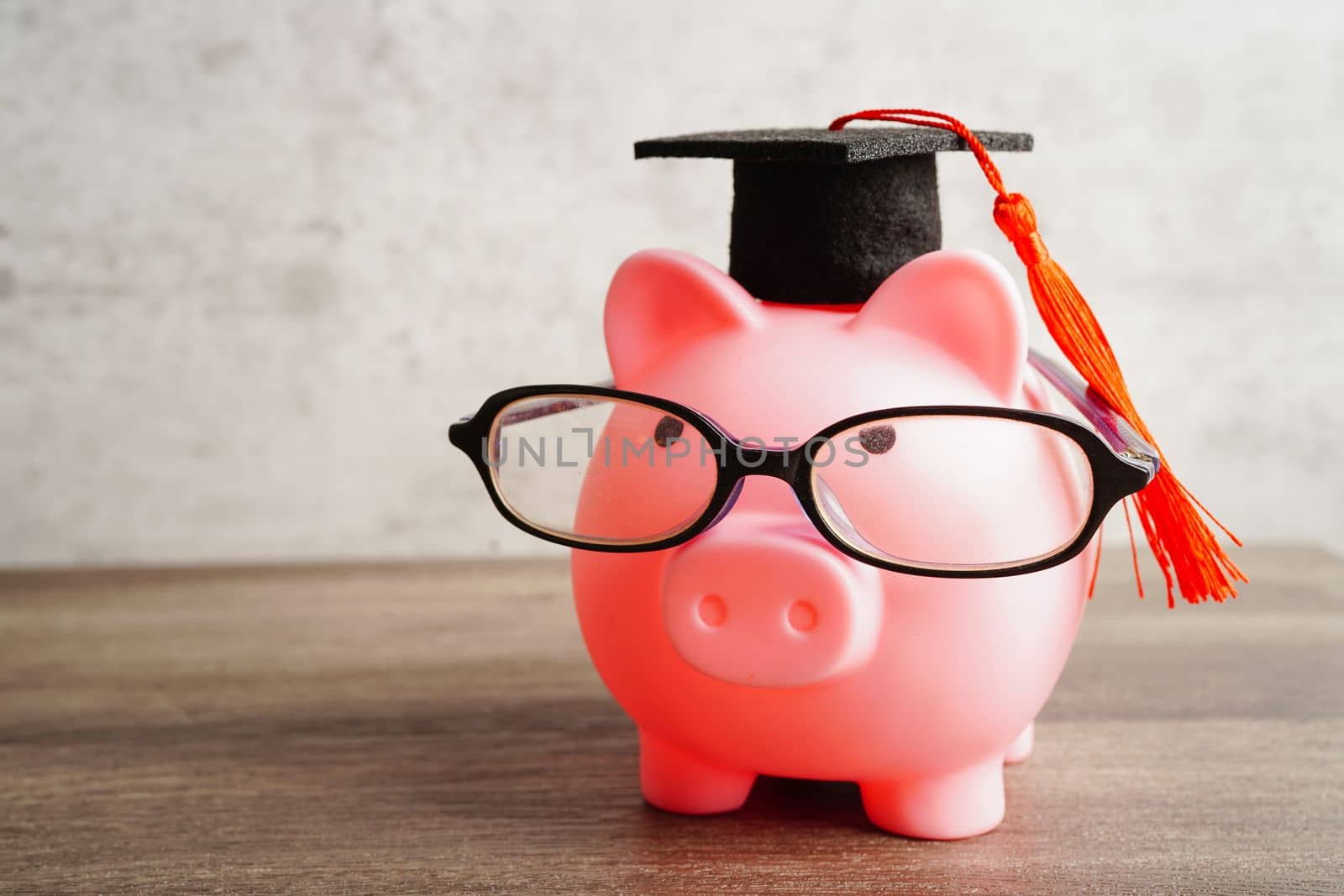 Pigging bank wearing eyeglass with coins and calculator saving bank education concept.