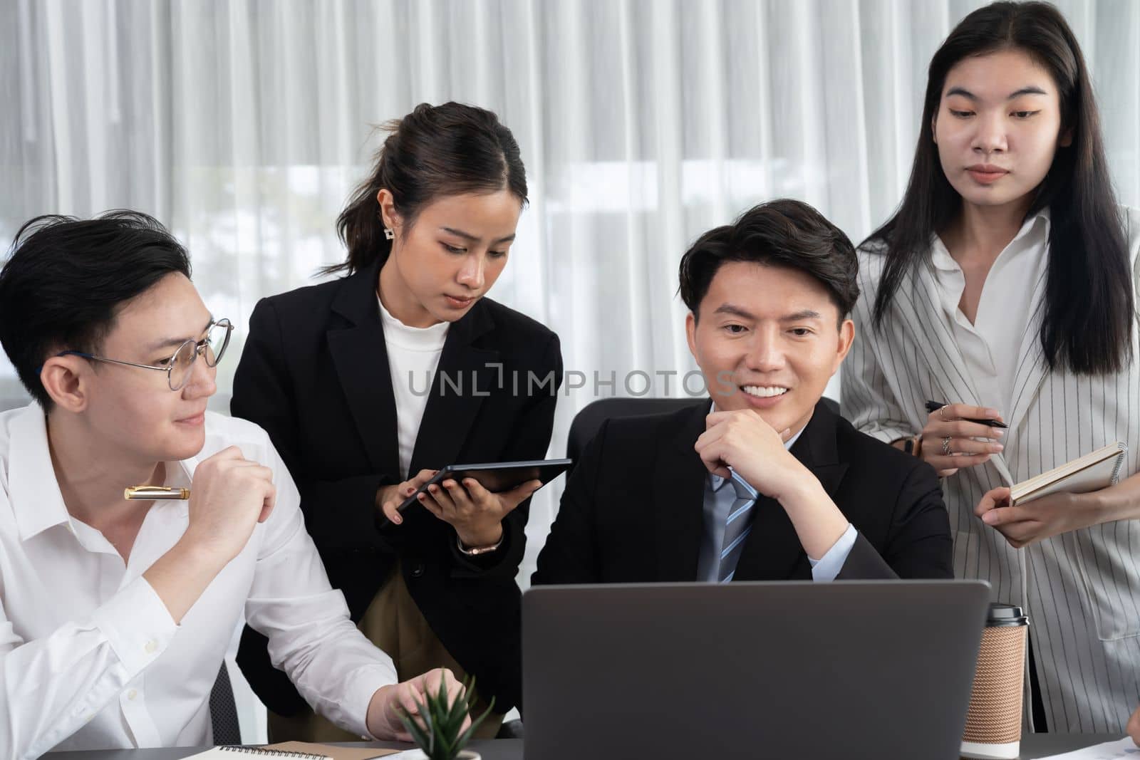 Harmony in office concept as business people analyzing dashboard paper together in workplace. Young colleagues give ideas at manager desk for discussion or strategy planning about project.