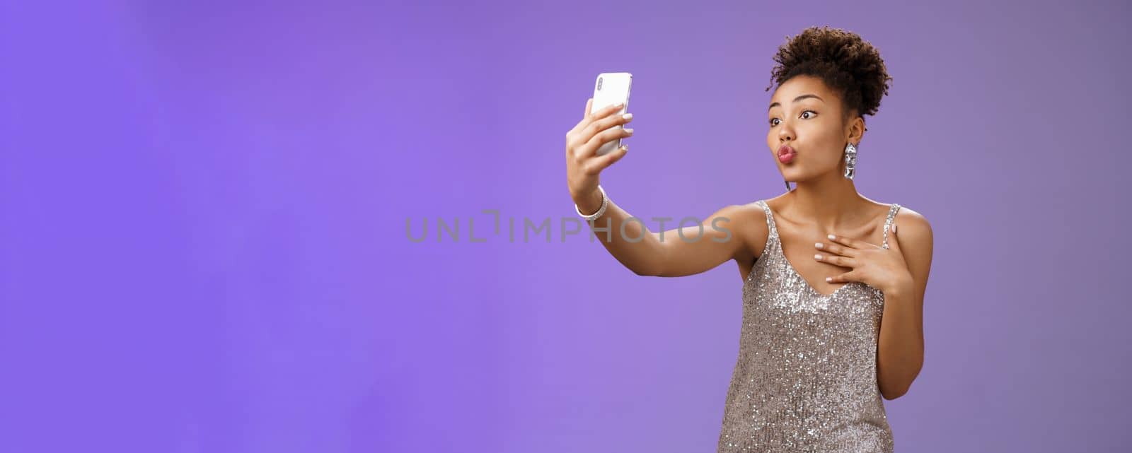 Stylish silly feminine african-american woman partying in silver stylish dress folding lips mwah gesture posing selfie taking photo during party night club looking flirty display camera by Benzoix
